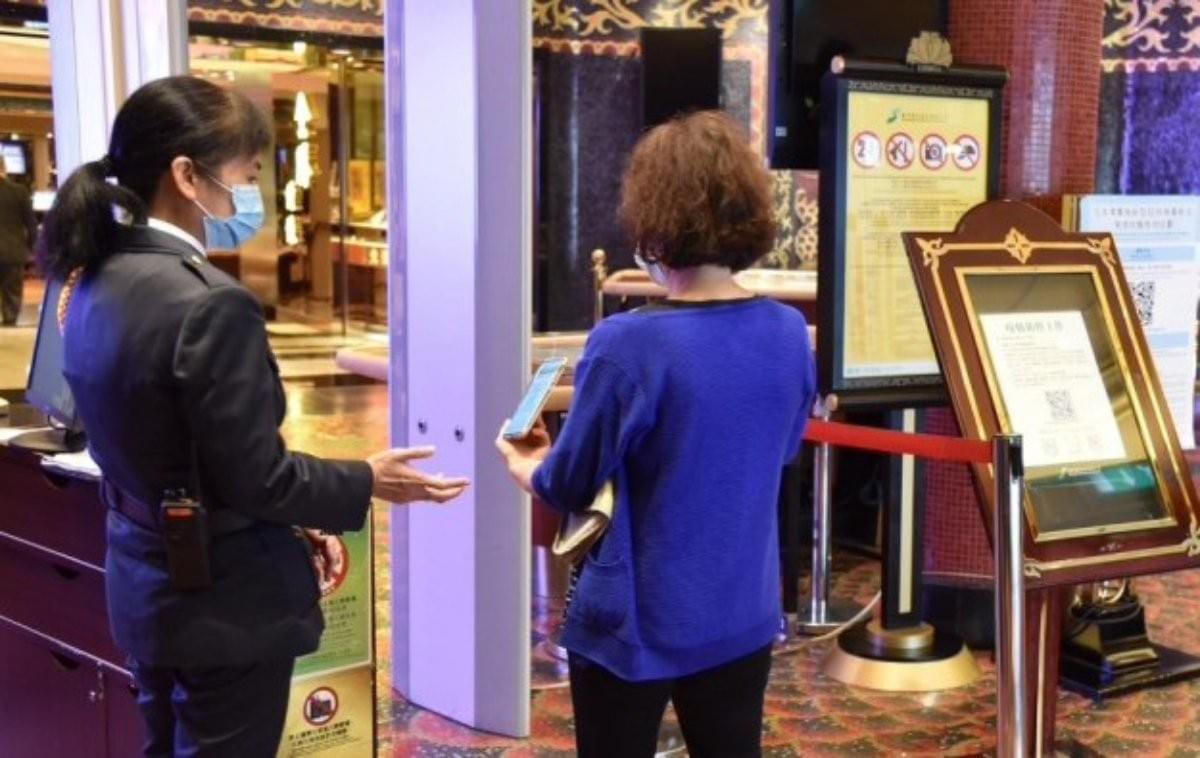 今年早些時候，一位顧客向安全官員展示了他們在澳門賭場的 COVID-19 陰性測試結果。由於地區衛生官員準備應對冠狀病毒病例的激增，此類入境程序已不再適用。（圖片：GGRAsia）